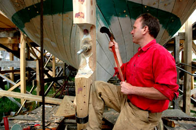 Harold A. Burnham using an adze.