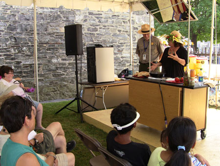 Eleni Zohdi cooks while ranger David Blackburn looks on.