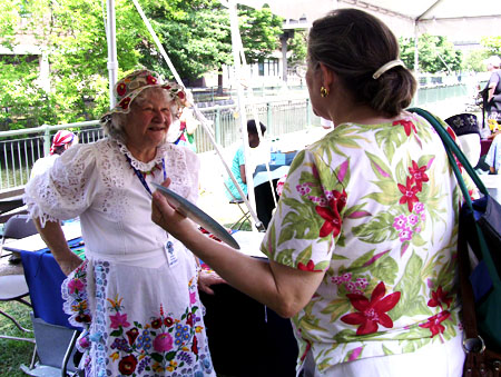 Eniko Farkas talks about embroidery with a visitor.