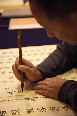 Qianshen Bai demonstrating calligraphy brush stroke. Photo by Billy Howard