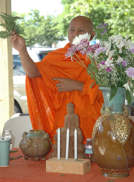 Monk sprinkling water and chanting